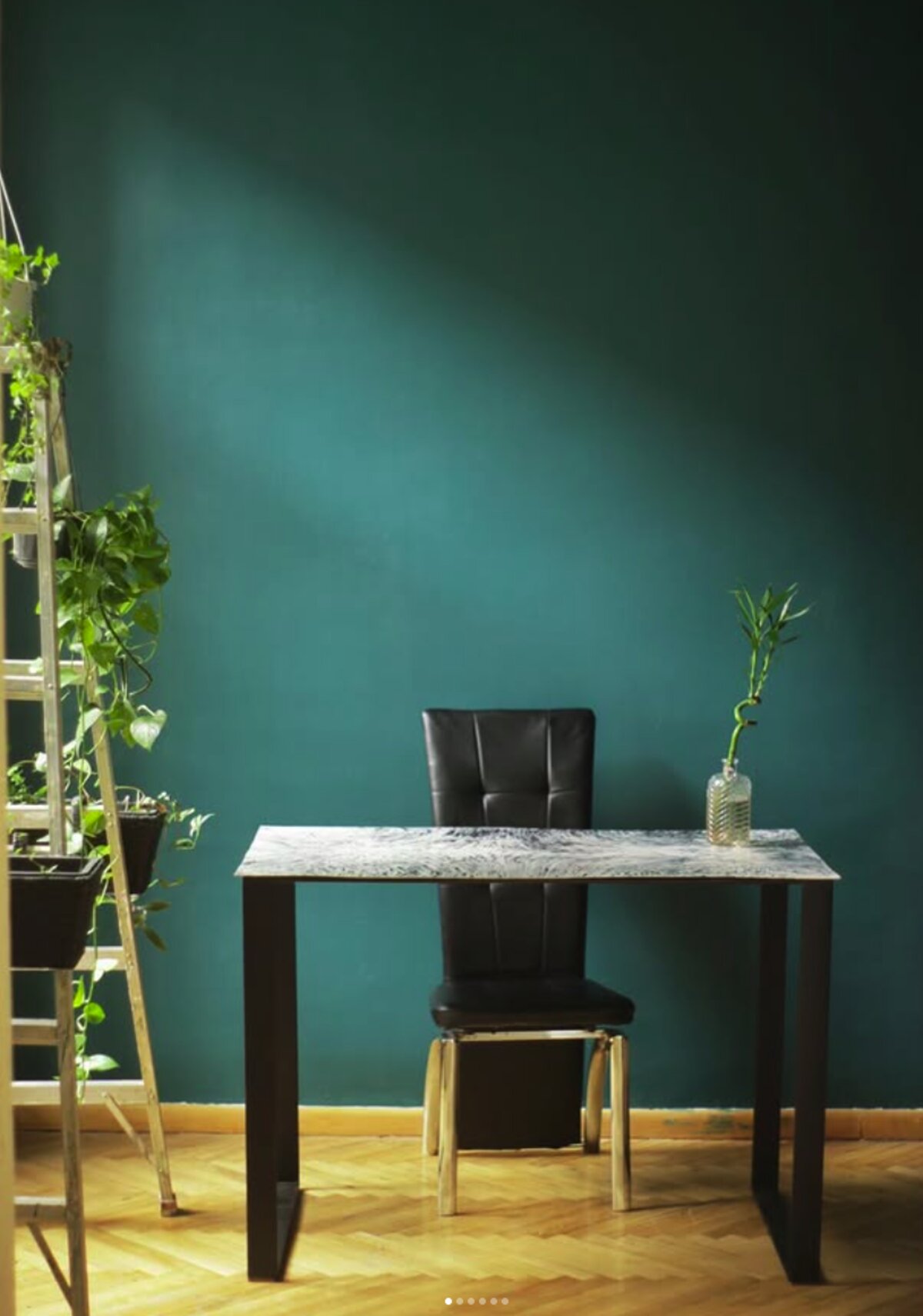 Recycled-plastic sheet desk with black steel legs against a green wall